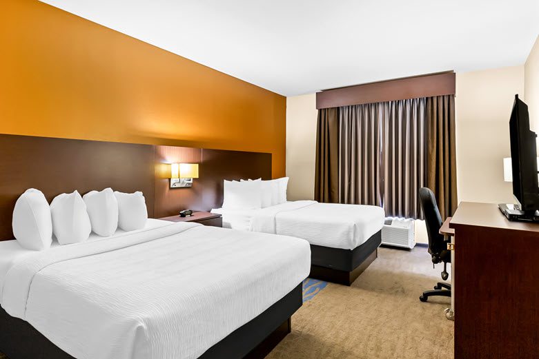A guest room with two beds at the Best Western St. Louis Airport North Hotel & Suites