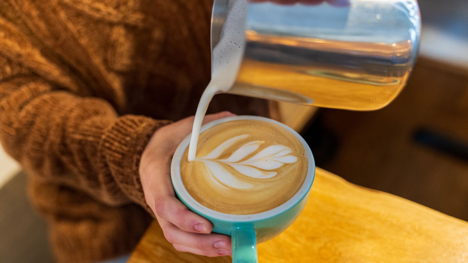 A barista pours a latte at Maypop Coffee and Garden Shop.